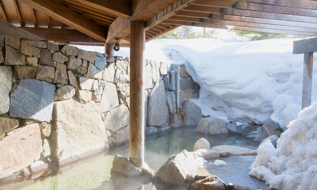 Outdoor onsen with wind swept snow creating a wall of snow and ice