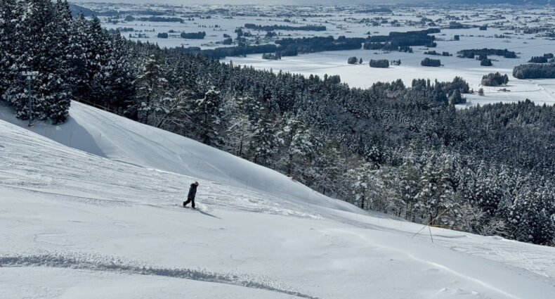 Snowboarder riding light powder on the Champion Course.